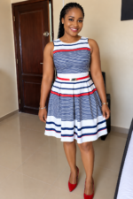 Femme souriante portant une robe trapèze sans manches marinière blanche à rayures bleu marine et rouges taille 40-42 Bambinerie Maternita Dakar