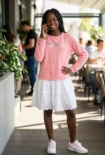 Jeune fille portant la robe ado 2-en-1 sweat rose selfie et jupe blanche broderie anglaise Maternita Dakar